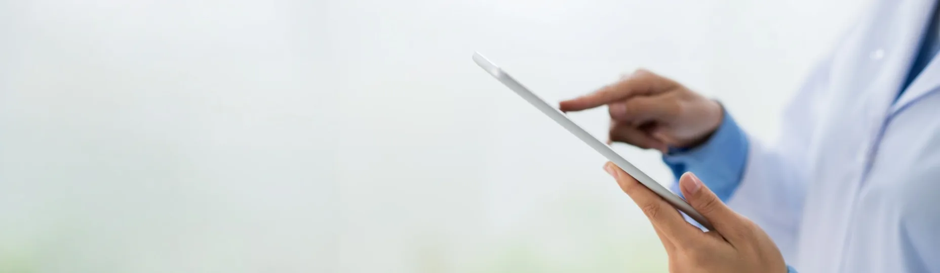 Doctor in a white coat using a tablet