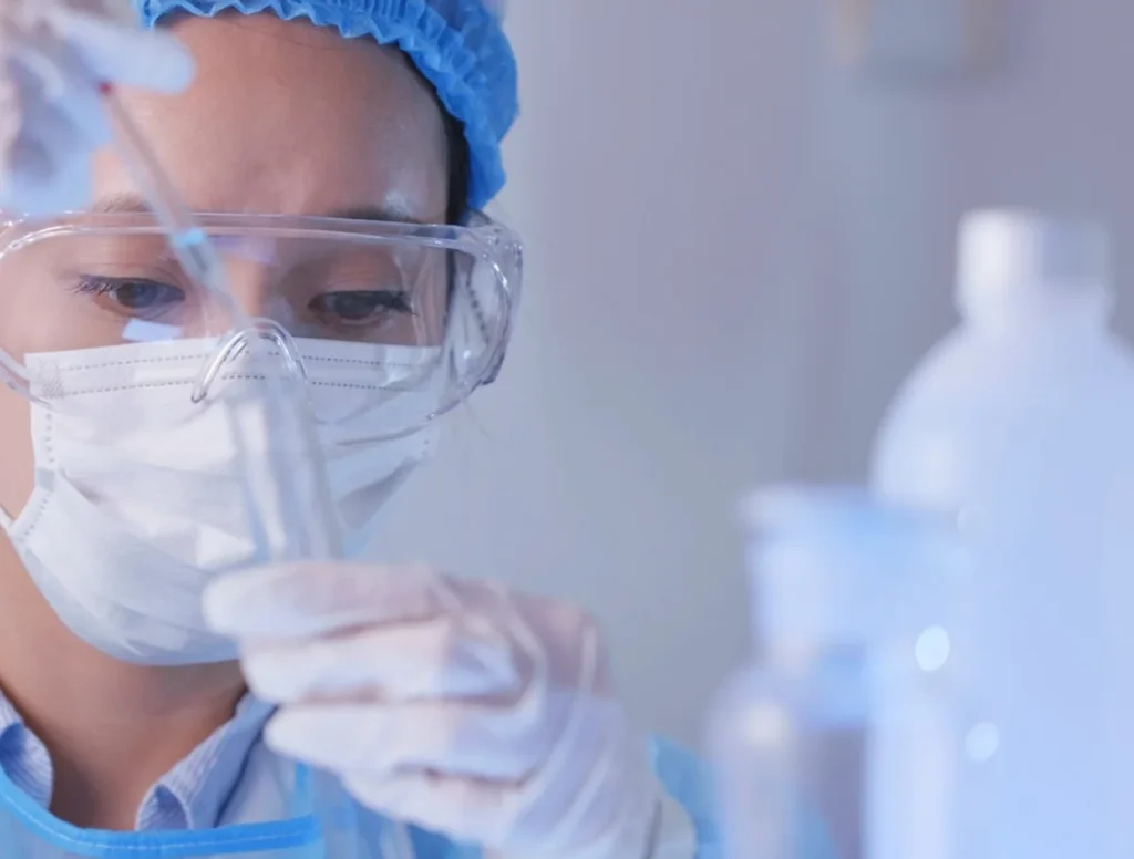 Laboratory specialist filling a test tube with a pipette