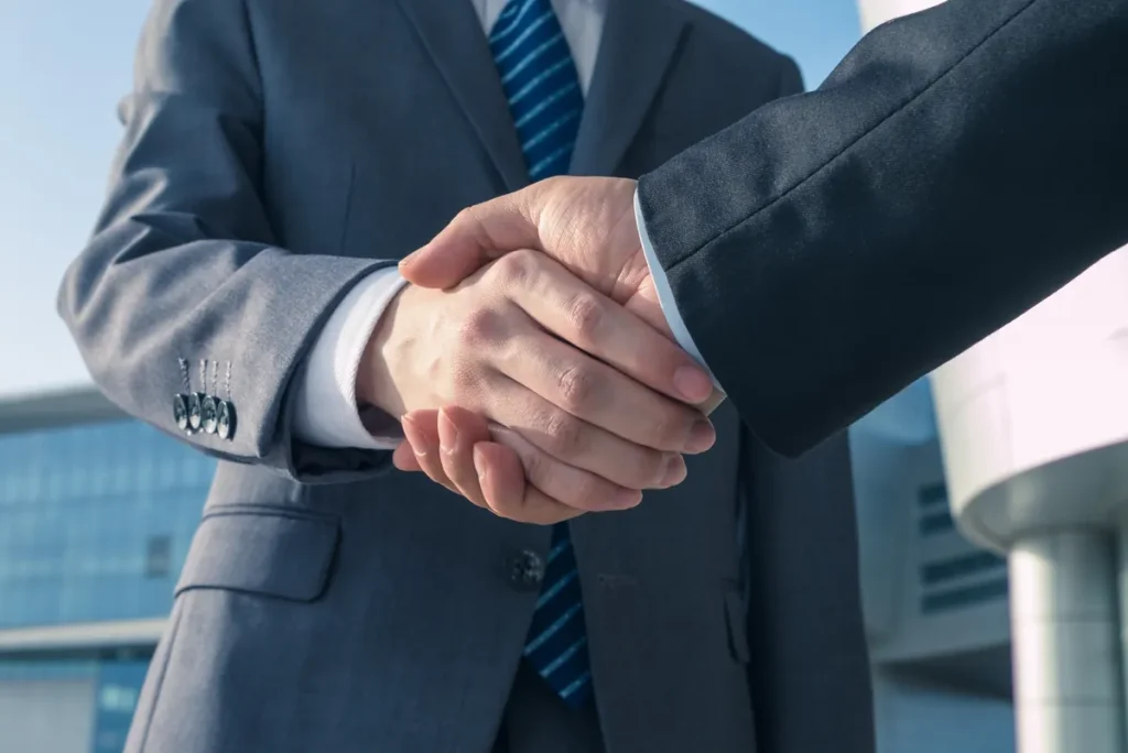 Two specialists shaking hands after a partnership meeting