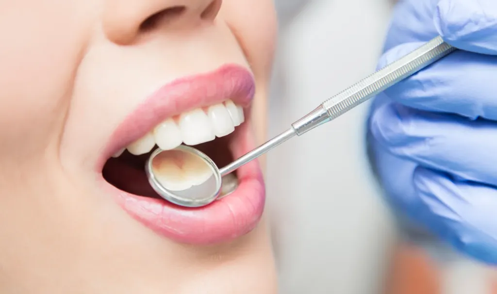 Dentist examining a patient's teeth with a dental mirror