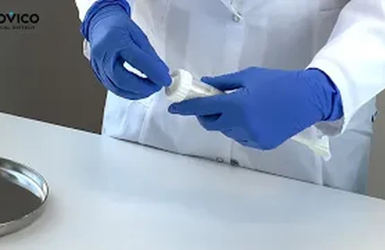A specialist in blue gloves opening an Ossylbone package in a laboratory